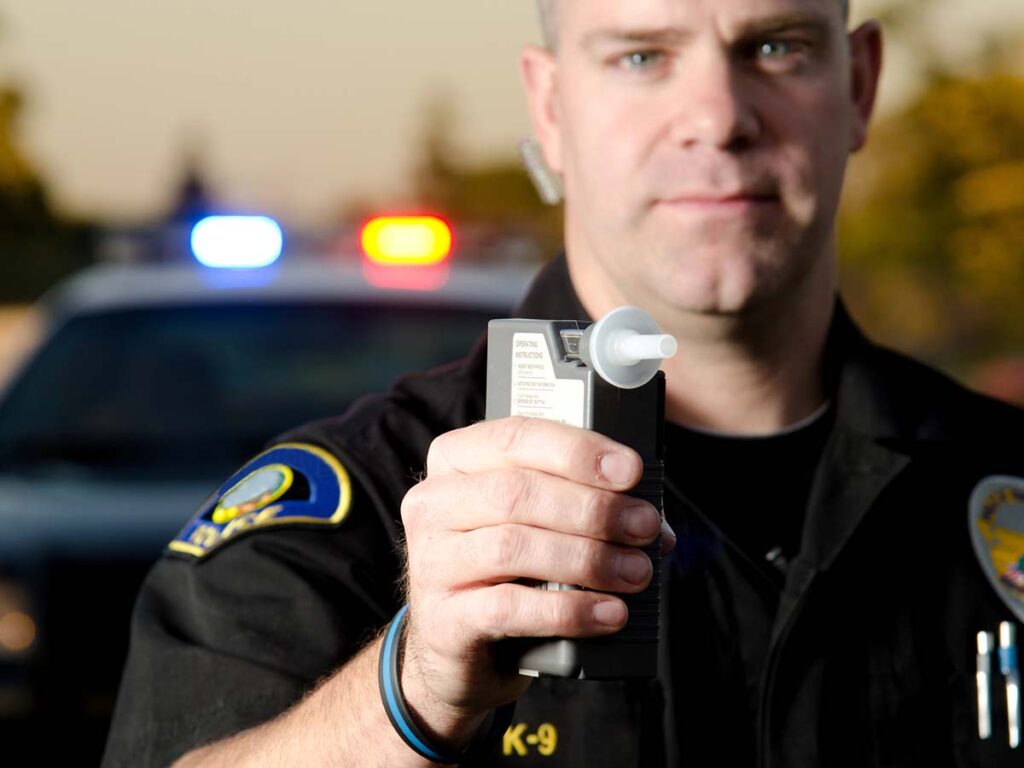 Cop holding breathalyzer machine